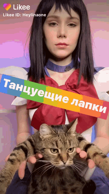 a woman in a sailor moon costume holds a cat in her hands