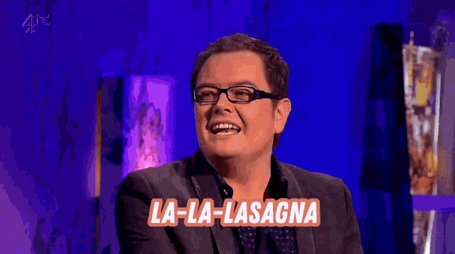 a man and a woman sit at a table with a sign that says la-la-lasagna with