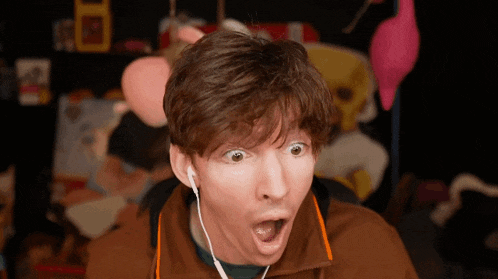 a man with a surprised look on his face wearing earbuds