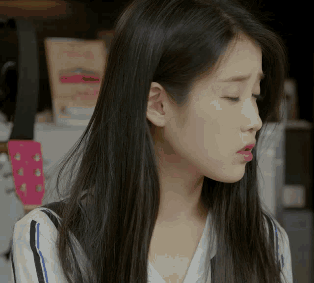 a close up of a woman 's face with a striped shirt