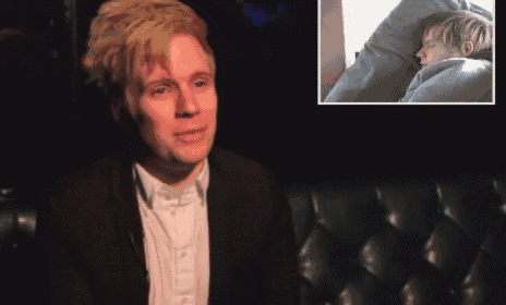 a man in a suit sits next to a picture of a child