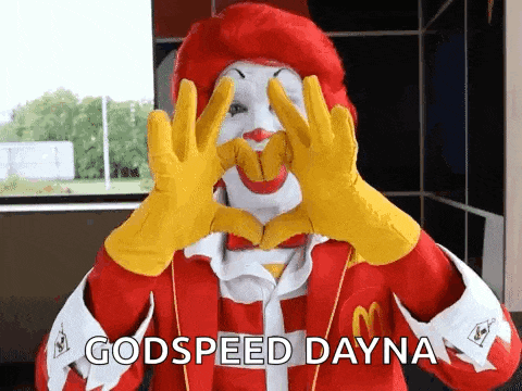 a mcdonald 's clown is making a heart with his hands