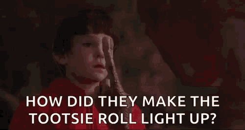 a young boy is holding a flashlight and asking how did they make the tootsie roll light up ?