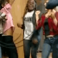 a group of people are dancing in a room and one of them is wearing a shirt that says ' cakes ' on it