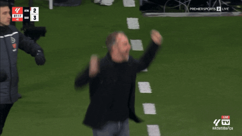a man stands on a soccer field in front of a scoreboard that says premier sports 2 live