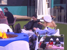 a group of people are sitting around a fire pit on a patio .