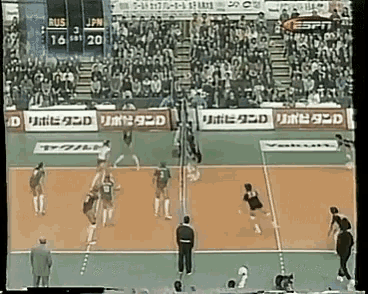 a volleyball game is being played in front of a crowd with ads for espn and jpn
