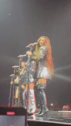 a woman is singing into a microphone on stage