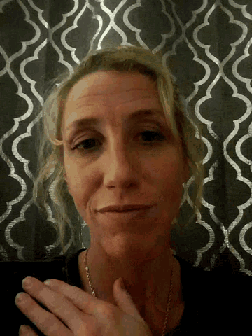 a woman 's face is shown in front of a wall with a pattern