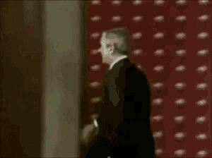 a man in a suit is opening a door with a key