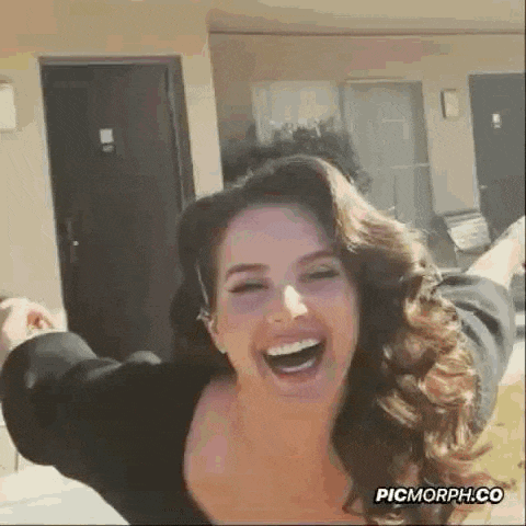 a woman with long hair is laughing with her arms outstretched .