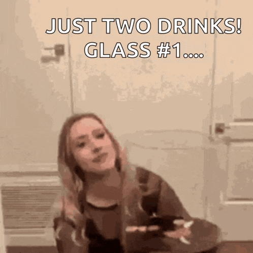 a woman is sitting at a table holding a glass of wine and a cell phone .