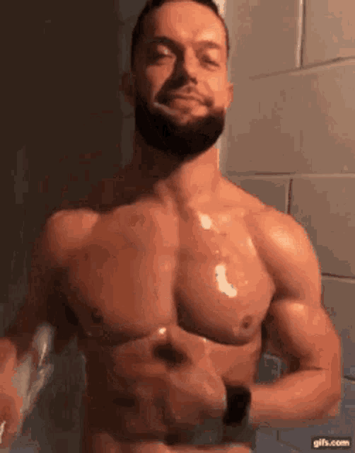 a shirtless man with a beard is brushing his teeth with a toothbrush in a bathroom .