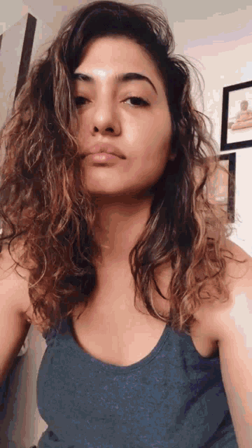 a woman with curly hair takes a selfie