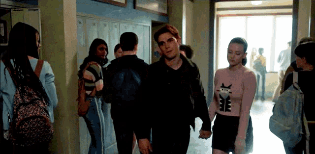 a man and a woman are holding hands in a hallway