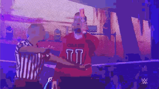 a man in a red jersey with the number 77 on it stands next to a referee
