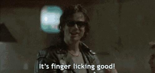 a man wearing sunglasses is saying `` it 's finger licking good ! ''