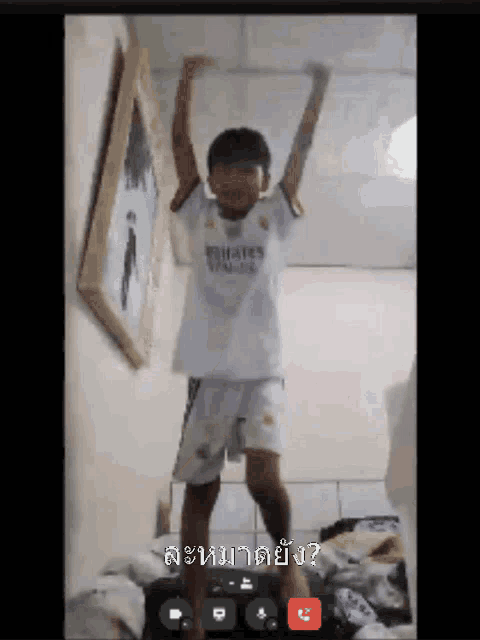 a boy in a emirates shirt is dancing