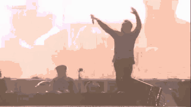 a group of people standing on top of a stage with their hands in the air .