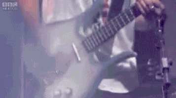 a man is playing a guitar on a stage in a blurry photo .