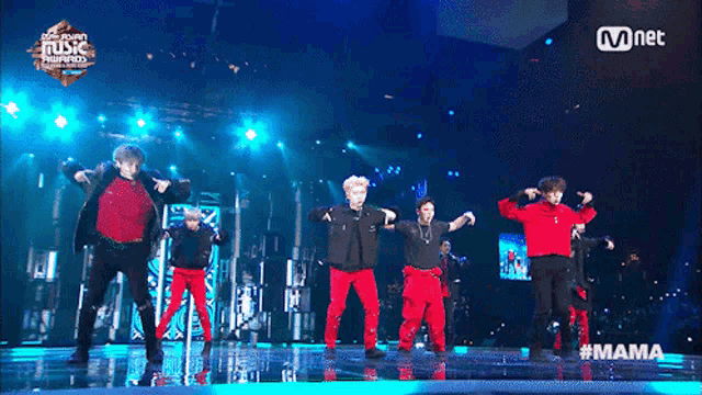a group of young men are performing on a stage at a mnet music awards show