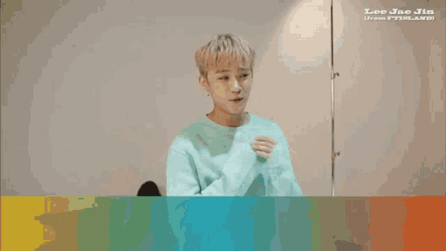 a young man in a blue sweater with asian writing on the bottom