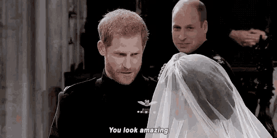 a man in a black suit is standing next to a woman in a veil and says `` you look amazing '' .
