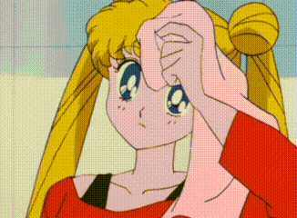 a girl in a red shirt is holding a pink towel to her face .