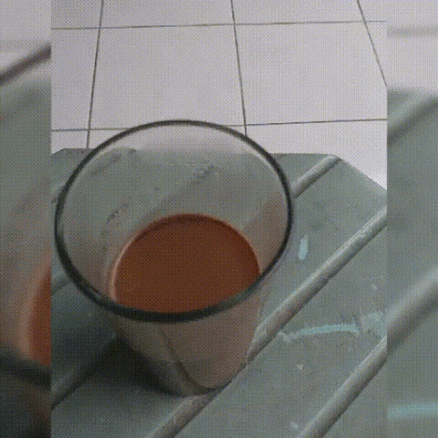 a glass of brown liquid is sitting on a table .