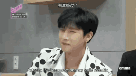 a man in a polka dot shirt is making a funny face while talking to someone .