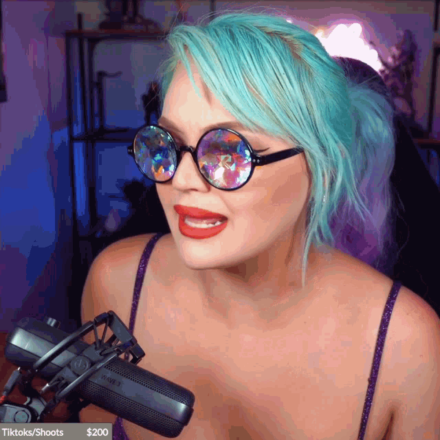 a woman with blue hair is talking into a microphone with a banner that says tiktoks / shoots at the bottom