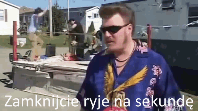 a man wearing sunglasses and a blue shirt that says zamknijcie ryje na sekunde on it