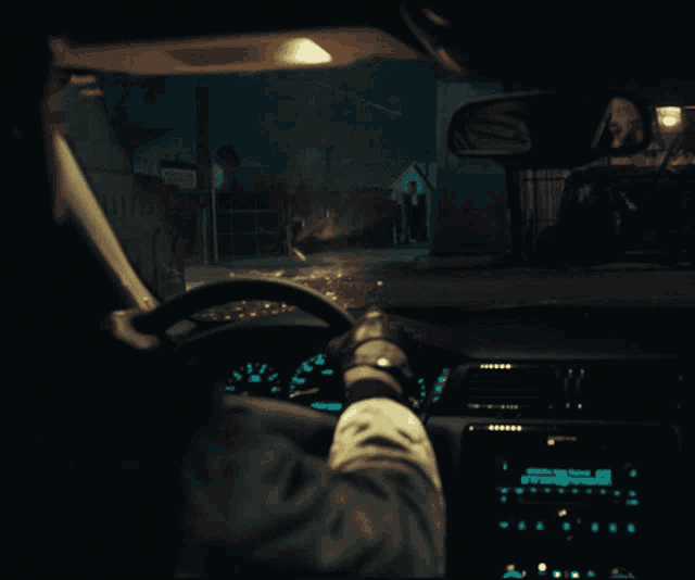 a person driving a car at night with a sign that says ' a ' on the side