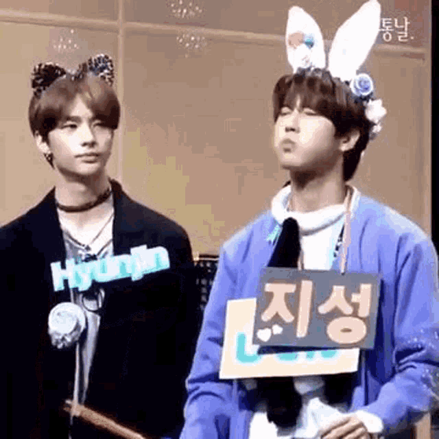 a couple of young men standing next to each other wearing bunny ears .