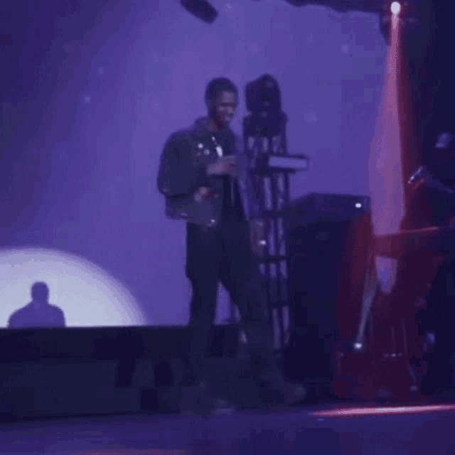 a man is singing into a microphone on stage