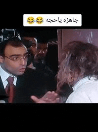 a man and a woman are talking to each other in a room .