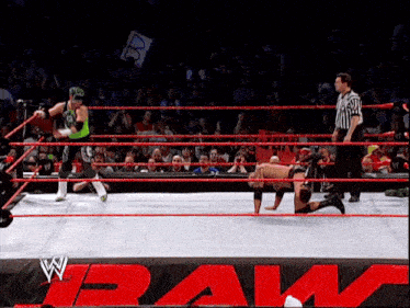 wrestlers in a wrestling ring with the word raw in the background