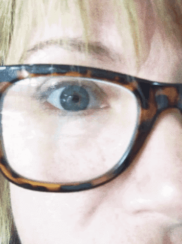 a close up of a woman 's eye with glasses on