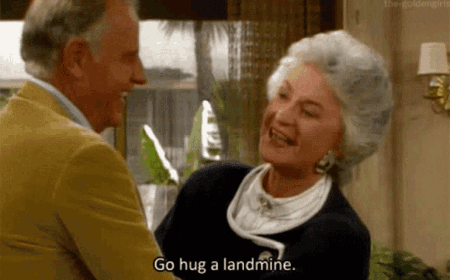 a man and a woman are hugging each other in a living room .