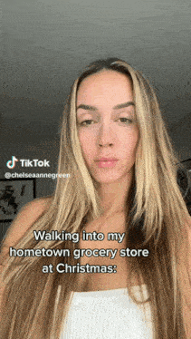 a woman is walking into a grocery store at christmas