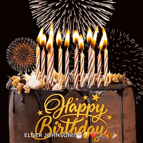 a birthday cake with candles lit up and fireworks behind it .