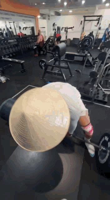 a man wearing a conical hat is lifting a barbell