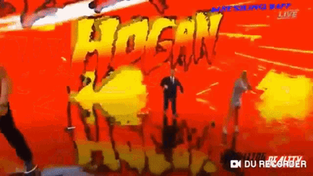 a man in a suit is standing in front of a sign that says hogan hawks