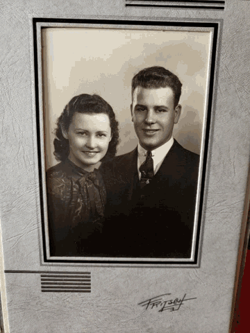a black and white photo of a man and a woman with a signature on the bottom right corner
