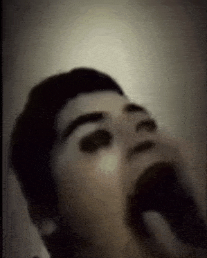 a blurry picture of a person 's face with their mouth open