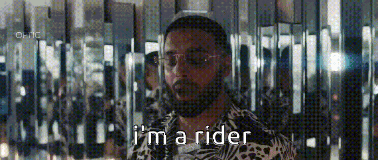 a man with a beard and sunglasses is standing in front of a mirror and says `` i 'm a rider ''