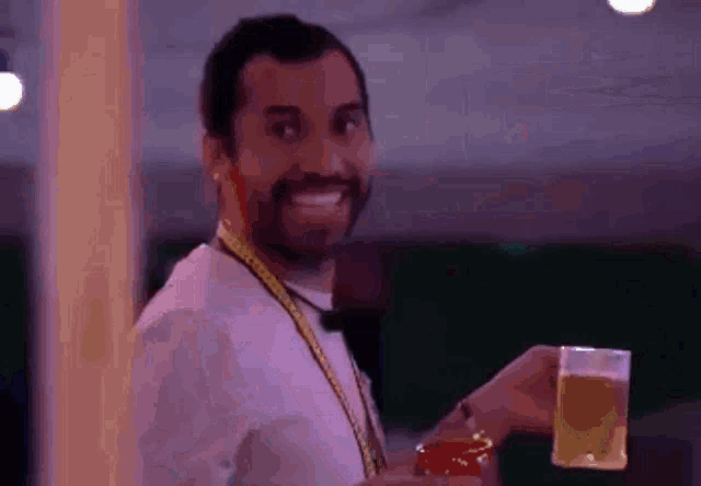a man with a beard is holding a glass of beer and a jar of jam .