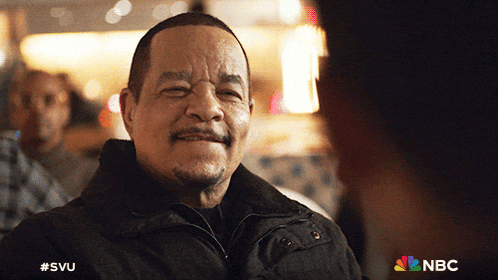 a man is smiling in front of a nbc ad