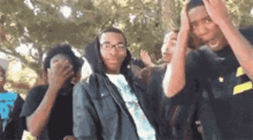 a group of young men are standing next to each other in a park .