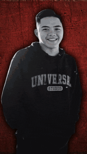 a man wearing a black universal studios hoodie